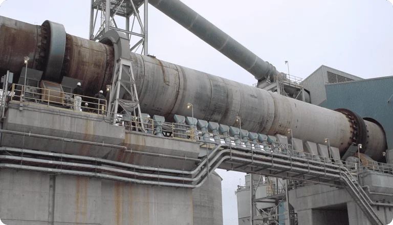 Cement precalciner tower with industrial pipelines and steel structure.