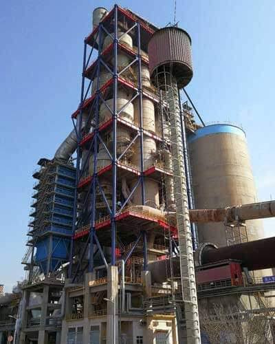 Cyclone preheater tower with rotary kiln and cement plant infrastructure.