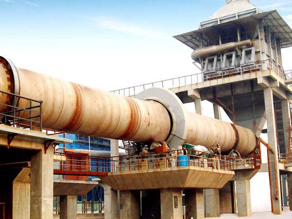 Rotary kiln dryer with support frames in workshop facility.